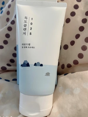 Round Lab 1025 Dokdo Cleanser 150ml - Mild ansiktsrengöring från Round Lab i en vit och ljusblå tub med illustration av hav och klippor. Innehåller 150 ml och är tillverkad i Korea. Perfekt för daglig rengöring och passar de flesta hudtyper.