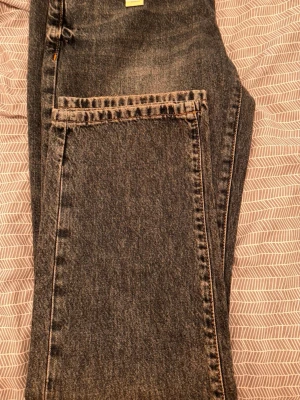 Gråa raka jeans från Woodbird - Snygga gråa jeans från Woodbird med rak passform och klassisk femficksdesign. Jeansen har en tvättad look och är tillverkade i bomull. Perfekta för en avslappnad och trendig stil.