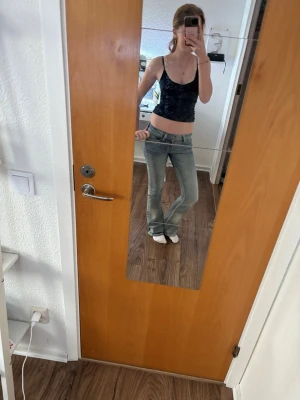Ljusblå bootcut jeans med låg midja - Säljer ett par ljusblå jeans med låg midja och bootcut passform. Jeansen har klassisk femficksdesign och är tillverkade i denim med lätt tvättad look. Perfekta för dig som gillar en avslappnad och trendig stil.
