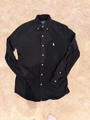 Polo Ralph Lauren featherweight mesh skjorta - Säljer denna svarta mesh skjorta från Ralph Lauren. Aldrig använd. Ny pris 2200kr. Storlek XS