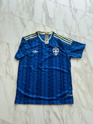 Blå Sverige Adidas matchtröja - Blå Sverige tröja. Väldigt snygg och skön att bära på speciellt nu under sommar. Storlek M. Hör av er!