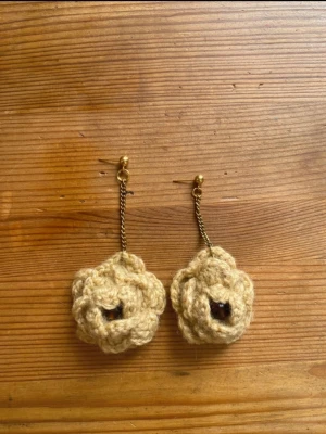 Beige virkade blomörhängen - Mina handgjorda örhängen.  Beiga virkade blommor och guldig metallkedja.  Nickelfria!  Följ min Instagram för mer <3 @veras.smycken. Unika handgjorda örhängen med virkade blommor i beige garn. Hängande modell med guldfärgade detaljer och kedja. Perfekta för dig som vill sticka ut med ett kreativt och bohemiskt smycke.