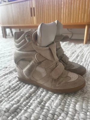 BEKETT - isabel marant skor - Snygga beige sneakers med högt skaft och flera kardborreband. Trendiga, perfekta för hösten!!  Har bud på 2100kr. Skorna är lite slitna och man ser att dem är använda, men dem gör sitt jobb och är superfina på. Skorna ser helt normala ut på.