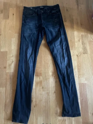Svarta  slim fit jeans - Snygga Svarta slim fit jeans med klassisk femficksdesign och smal passform. Jeansen har en lätt tvättad look och raka ben. Perfekta för dig som gillar en stilren och enkel look till vardags.
