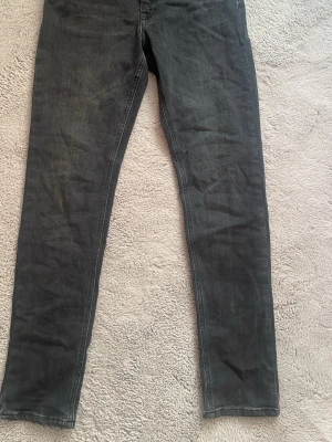 Svarta slim fit jeans - Snygga svarta slim fit jeans med klassisk femficksdesign och diskreta sömmar. Jeansen har en smal passform och raka ben, perfekta till en avslappnad stil. Materialet är mjukt och stretchigt för extra komfort.