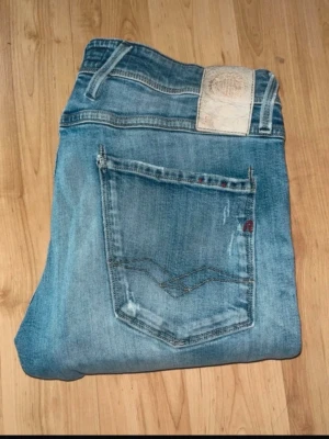 Replay Anbass jeans  - Ljusblåa Anbass jeans från Repaly med slitningar och hål på knäna. Midja 38cm, längd 115cm. JAG SKICKAR EJ FLER BILDER NÄR JAG BÄR JEANSEN! för bättre inblick i passformen rekommenderar jag att googla på modellnamnet. För storleksguide kolla måtten noggrant då jeansen alltid kan vara uppsydda heller krympta och jag ej tar emot returer :) 