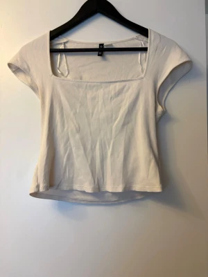 Vit ribbad topp från H&M Divided - Säljer en vit ribbad topp från H&M Divided med fyrkantig ringning och korta ärmar. Toppen har en croppad passform. 