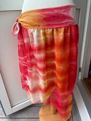 Somrig cover up kjol  - Vacker cover up kjol, fina glittriga detaljer i tyget. Har knyte så passar Xs-M (går att knyta mellan ca 90-115 cm) Vi har sytt den själva, säg gärna till om ni vill ha något costumdesigned!   