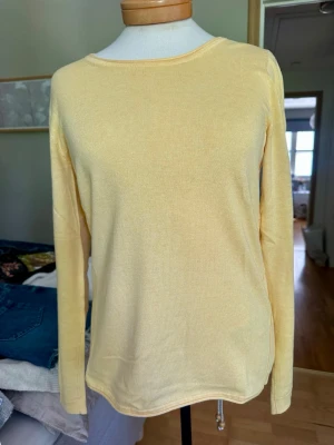 Gul långärmad tunn tröja från Esprit - Ljusgul långärmad tröja från Esprit edc med rund halsringning. Tröjan är tunnstickad och har en enkel, stilren design som passar perfekt till jeans eller kjol. Materialet känns mjukt och bekvämt mot huden.