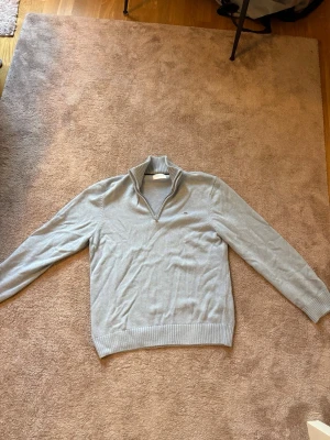 Ljusgrå stickad tröja med halv dragkedja - Ljusgrå stickad tröja med halv dragkedja. Perfekt för lager på lager och enkel att matcha med olika outfits. Nypris 1300