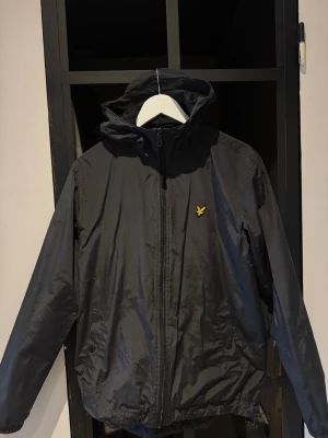 Svart vindjacka med huva - Snygg svart vindjacka/ regn jacka med luva från lyle & scott storlek M 