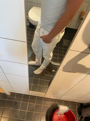Vita raka jeans - Säljer ett par vita jeans med rak passform och klassisk femficksdesign. Jeansen har metallnitar vid fickorna och bälteshällor i midjan. Perfekta för dig som vill ha en clean och stilren look till vardags. Materialet är kraftig denim i bomull.
