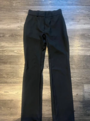 Svarta kostymbyxor med raka ben - Stilrena svarta kostymbyxor med rak nästan bootcut passform och hällor för bälte. Från Cubus i storlek 36 men jag har själv sytt dem till lågmidjad så skulle säga närmare 34 i storlek Byxorna har en enkel design men ett tyg som livar upp de lite mer än vanliga ”kostym” tyger och är perfekta för en clean och snygg look. 