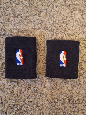 Nike x NBA wristband  - Ett par snygga svarta Nike x NBA wristband. Aldrig använda och skicket är helt ny. Slitningar skador eller defekter finns. Passar superbra för all träning samt vardaglig användning. Skick: 10/10