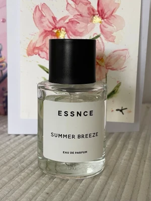 ESSNCE Summer Breeze - Fräsch parfym från ESSNCE med namnet Summer Breeze. Flaskan är cylindrisk i genomskinligt glas med svart rund kork och enkel vit etikett. Doften är Eau de Parfum och ger en modern och stilren känsla. Perfekt för dig som gillar lätta och somriga dofter.