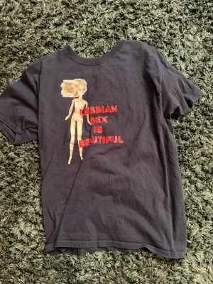 Lesbian sex is beautiful - Svart T-shirt med Barbie ”lesbian sex is beautiful” thriftad och ingen lapp så oklart vad storleken är men skulle säga att den passar som M