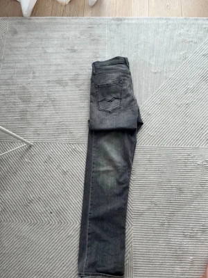 Grå Replay jeans - Snygga grå jeans från Replay med raka ben. Jeansen har en diskret tvättad look och detaljerade sömmar på bakfickan. Perfekta för dig som gillar stilrena och tidlösa plagg i garderoben. Storlek: 32/32. Säljer då de inte passade mig.