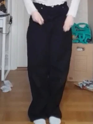 Svarta baggy jeans med hög midja - Säljer ett par svarta baggy jeans med hög midja. Jeansen har en avslappnad passform och klassisk femficksdesign. Säljer då dem är för små.