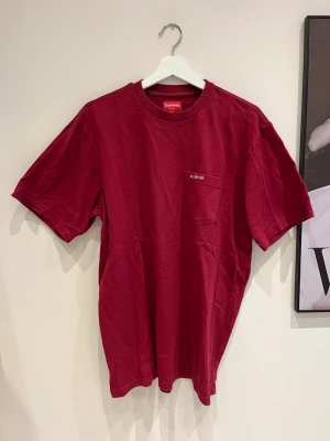 Röd Supreme t-shirt med bröstficka - Snygg röd t-shirt från Supreme i fint skick. Säljer åt min pojkvän. 
