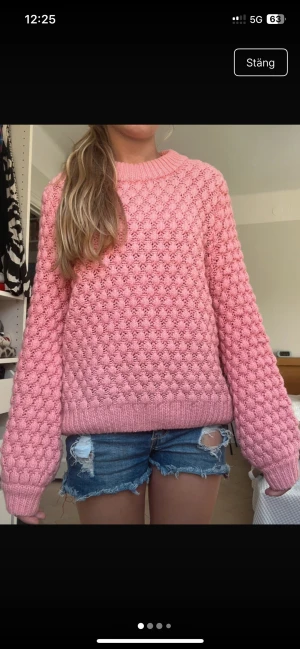 Rosa bubblig stickad tröja - Superfin rosa stickad tröja med bubbligt mönster och rund hals. Tröjan har långa ärmar och ribbade muddar vid ärmslut och nederkant. Perfekt för dig som gillar en mysig och trendig look.