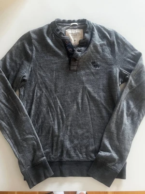 Abercrombie & fitch Henley tröja sweatshirt (sällsynt ) - Riktigt snygg och eftertraktad Abercrombie & fitch Henley tröja. fint skick inga fel storlek M kan ta mått vid behov. Endast 340 ej hugget i sten kom gärna med frågor och prisförslag har även mycket mer liknande i min profil alla storlekar kolla gärna stor rabatt vid köp av flera 😁✌️