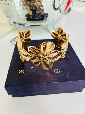 S.steel flower bangle  - Vackert blommigt armband i rostfritt stål, okänt märke. Nytt och justerbart.