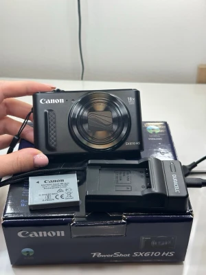 Canon PowerShot SX610 HS digitalkamera - Snygg svart Canon PowerShot SX610 HS digitalkamera med 18x optisk zoom och inbyggd blixt. Kompakt design i metall och plast, perfekt för att ta med överallt. Levereras med originalbatteri, laddare och förpackning.