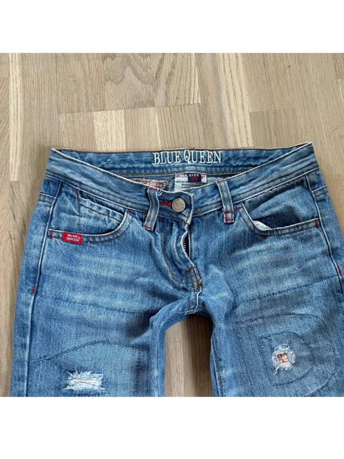 Ljusblå slitna bootcut jeans