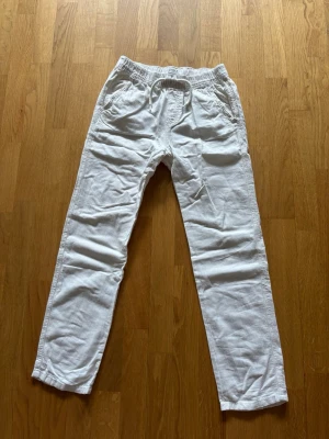 Vita linnebyxor  - Säljer ett par vita linnebyxor med avslappnad passform och resår i midjan. Byxorna har sidofickor och raka ben. Storlek 164 men passar xs.