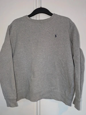 Polo Ralph Lauren sweatshirt - En klassisk grå sweatshirt från Polo Ralph Lauren med rund hals tröjan är i mycket bra skick. Barn XL. 