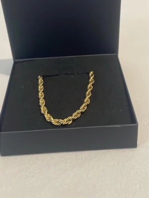 Tjockt tvinnat guldfärgat halsband - Säljer ett snyggt halsband i guldfärg med tvinnad kedja. Halsbandet har en chunky look och levereras i en svart ask. Perfekt för dig som vill ha ett statement-smycke med trendig känsla.