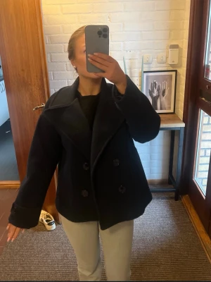 Svart skepparkavaj med bred krage - Säljer en svart skepparkavaj med dubbelknäppning och bred krage. 