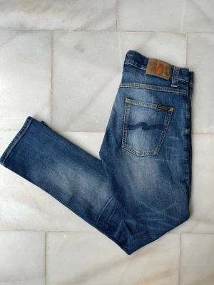Blå Nudie Jeans  - Säljer ett par riktigt schysta blå  Nudie Jeans men snygga slitningar. Modellen är Grim Tim 😁———————————————————————————                                                      📐| Storlek: 30-32                                                  👖| Märke: Nudie Jeans                                         🔎 | Skick: Mycket bra                                            💵 | Ny Pris: 1599kr                                                 ✍🏻 | Skriv om du har några frågor
