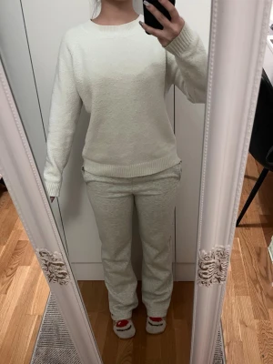 Vit stickad tröja - Säljer ett supermysigt stickad tröja i vitt med långärmad. Tröjan har rund halsringning och ribbade muddar. Materialet har blivit lite dåligt.