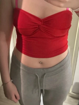 Röd ribbad croppad linnetopp - Trendig röd croppad linnetopp med ribbad struktur och twistad detalj framtill , perfekt för en snygg och enkel look. Materialet känns mjukt och stretchigt.