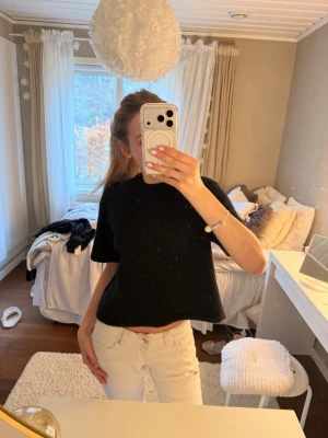 Svart stickad tröja - En enkel och stilren svart stickad tröja med korta ärmar. Perfekt att matcha med jeans eller kjol. . Använd cirka 1 gång.