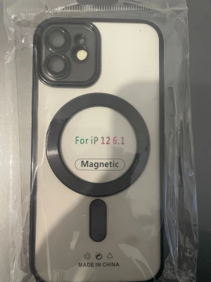 Magnetiskt skal till iPhone 12 6.1" och du får med kamerasydd för iPhone 12 - Säljer ett svartvitt magnetiskt mobilskal till iPhone 12 6.1 tum. Skalets baksida är vit med svart ram och har en stor magnetisk ring för MagSafe. Medföljer två linsskydd i härdat glas och rengöringsdukar. Perfekt för dig som vill skydda mobilen och använda MagSafe-tillbehör.