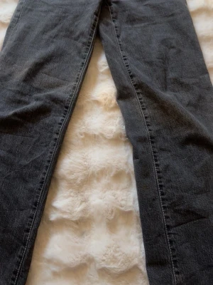Svarta raka jeans med fem fickor - Säljer ett par svarta jeans med rak passform och klassisk femficksdesign. Jeansen har normal midja och är tillverkade i ett mjukt denimtyg. Perfekta för dig som gillar en avslappnad och chefig stil.