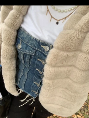 Blå denimkorsett med knappar - Trendig korsett i blå denim med framknäppning och dekorativa sömmar. Råa kanter nedtill ger en edgy look. Passar perfekt till lager-på-lager-stil eller som ensam stilren topp. Toppen är flexibel i storleken och passar allt från XS till M (står M på lappen) Skriv om ni har några frågor 🩷