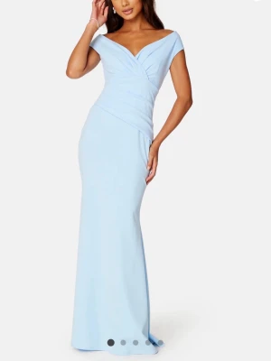 Ljusblå lång klänning  - Elegant ljusblå långklänning med off shoulder-skärning och draperad överdel. Klänningen har figurnära passform och lätt utsvängd kjol. Perfekt för bal eller speciella tillfällen. Materialet är mjukt och följsamt. Är som ny, ändrat använd vid ett tillfälle. Storlek S                                                             Ny pris: 999kr                                                 Säljs för: 500kr 