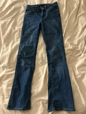Blå bootcut jeans från only - Säljer ett par blå bootcut jeans med medelhög midja. Jeansen har utsvängda ben.