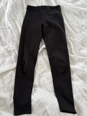 Svarta leggings från H&M Sport - Säljer ett par svarta leggings från H&M Sport med stretchigt material. Perfekta för träning eller chill dagar. Klassisk modell utan synliga detaljer eller fickor. Sitter tajt och bekvämt, passar till det mesta.💓