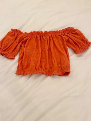 Orange offshoulder blus  - Säljer denna orange offshoulder blus med volangdetaljer och broderade hålmönster🫶🏼🫶🏼