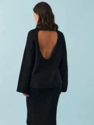 Svart stickad tröja med öppen rygg - Cool svart stickad tröja med djup, öppen rygg och långa ärmar. Tröjan har en avslappnad passform och är gjord i mjukt stickat material. Perfekt för dig som vill ha något unikt och trendigt i garderoben. Använd ett fåtal gånger, väldigt fint skick