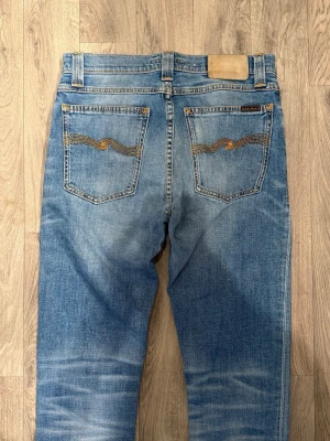 Nudie Jeans Blå W30/L32 - Slim Fit - Mycket fint skick. Mått - Midja: 37cm, Ytterbenslängd: 105,5cm, Benöppning: 15,5cm. Modellen är 185cm & 63kg. Hör av dig vid funderingar!🤝