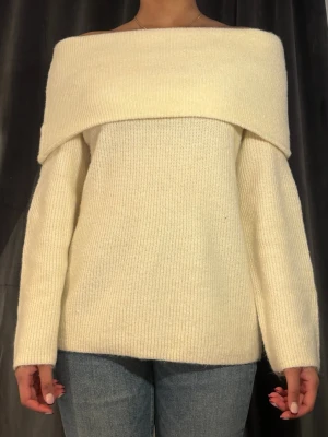 Off shoulder stickad tröja i cremevitt - Trendig off shoulder stickad tröja i cremevitt med bred krage som vilar över axlarna. Från Hm, oanvänd storlek S