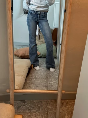Fina ljusblå jeans lågmidjade&bootcut - Säljer ett par snygga bootcut jeans i ljusblå denim med klassisk femficksdesign, lågmidjade! Jeansen har lätt slitning och använda (lagat på ett ställe som man kan se på en av bilderna med lite vit tråd!) midjemått:33cm Innerbenslängd: 77cm