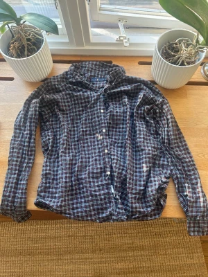 Ralph Lauren skjorta - Rutig långärmad skjorta i bomull - Knappt använd och i mycket bra skick. Snygg rutig skjorta med knappar och krage. Skjortan har en klassisk passform och är tillverkad i mjuk bomull. Färgkombinationen är mörkblå, röd och vit, vilket ger en tidlös look. Perfekt att styla med jeans eller chinos.