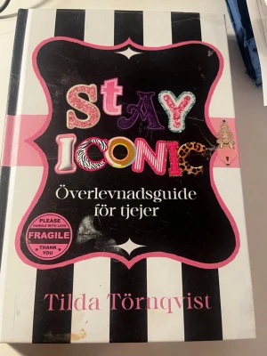 Stay Iconic: Överlevnadsguide för tjejer - En färgstark och inspirerande bok av Tilda Törnqvist med svartvitt randigt omslag, rosa detaljer och lekfulla bokstäver. Boken är en överlevnadsguide för tjejer som vill boosta självförtroendet och hitta motivation i vardagen.