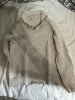 Beige stickad tröja med halvzip these glory days - Säljer en beige stickad tröja från Morris med halvzip och hög krage. Tröjan har lång ärm och ribbade muddar vid ärmslut och nederkant. Perfekt för lager på lager och enkel att matcha med olika outfits. Fet tröja från these glory days använd max 2 gånger